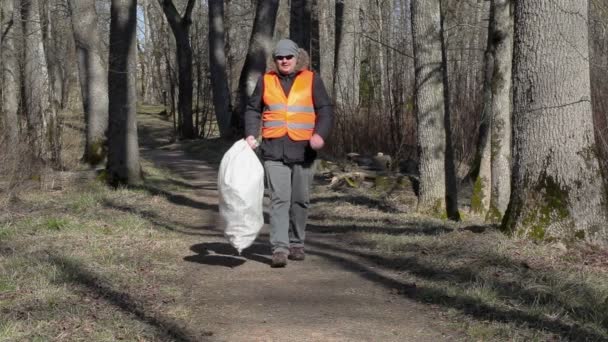 Man met slimme telefoon en tas van plastic flessen op pad — Stockvideo