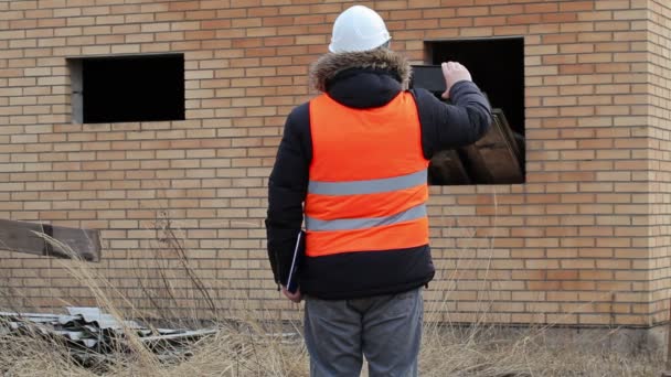 Ingeniero de equipos de seguridad con tablet PC y trabajador con tabla — Vídeo de stock