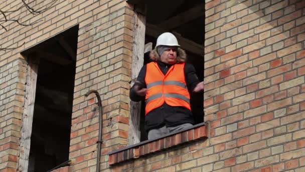 建物の 2 階の窓でのタブレット Pc の怒っているサイト マネージャー — ストック動画
