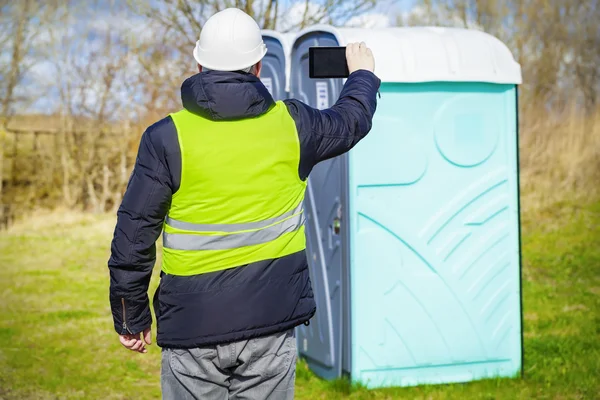 Inspector filmed on the tablet PC near portable toilets — Stock Photo, Image