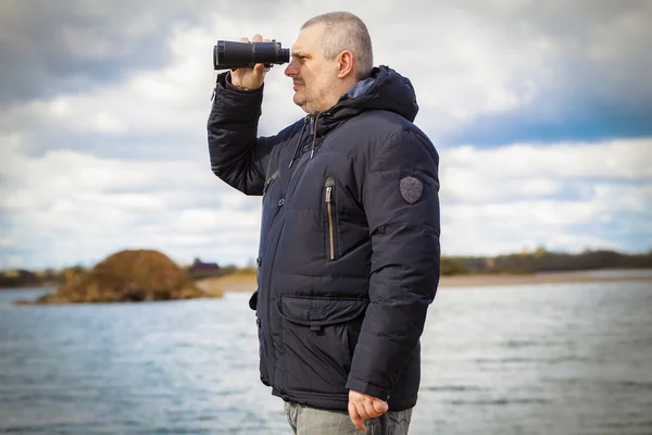 Man with binoculars at the lake — Stock Photo, Image