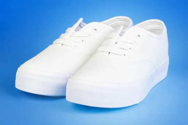 Flatform Plimsolls i vit på blå — Stockfoto