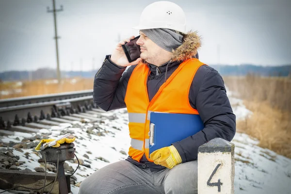 Funcionário ferroviário falando em telefone inteligente perto dos relés de sinal — Fotografia de Stock