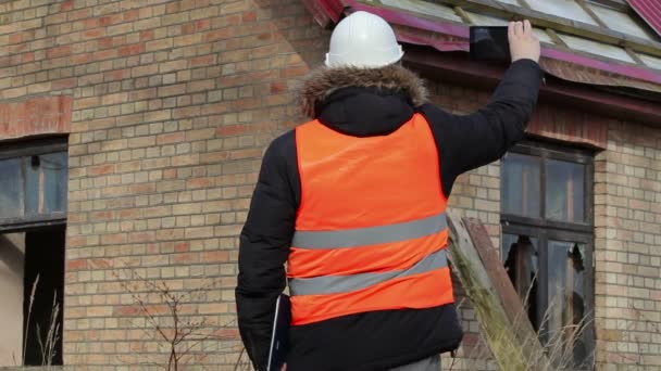 Inspector de construcción con tableta PC filmación techo del edificio — Vídeos de Stock