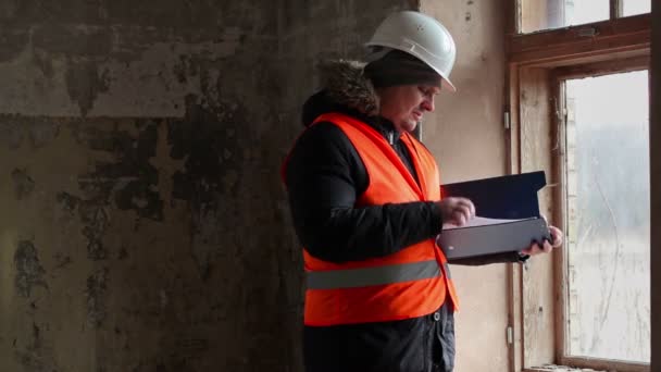 Inspector de edificio con documentación en habitación cerca de ventana — Vídeos de Stock