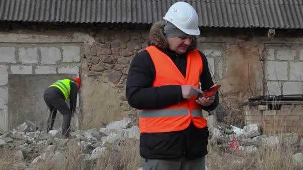Χτίζοντας επιθεωρητής με tablet Pc στο παρασκήνιο εργαζόμενος με slagdehammer — Αρχείο Βίντεο