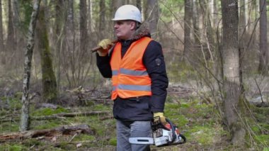 Oduncu chainsaw ve walking away ormanda balta ile 