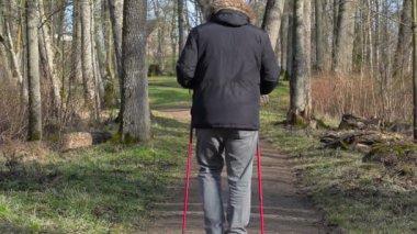 Uzun yürüyüşe çıkan kimse baston park yolundaki ile