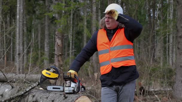 Zmęczony drwal w pobliżu chainsaw w lesie — Wideo stockowe