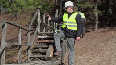 İşçi Tablet Pc kırık ahşap parça yakın resim çekmek 