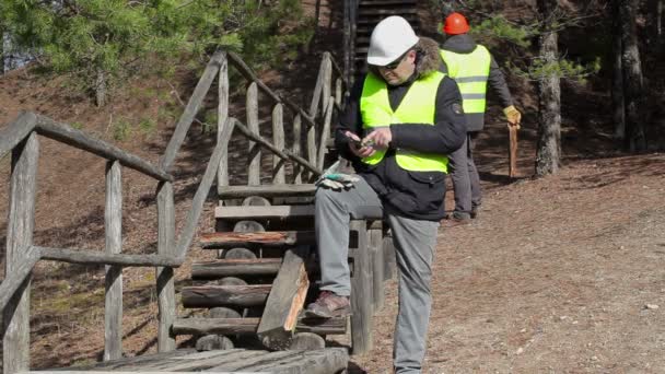 Trabajador que usa tableta PC cerca de la pista de madera rota — Vídeos de Stock