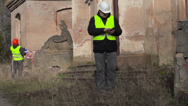 Строительный инспектор с помощью планшетного ПК в старой усадьбе — стоковое видео