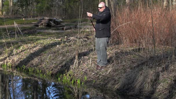男が川の近くの釣り竿を描画します。 — ストック動画