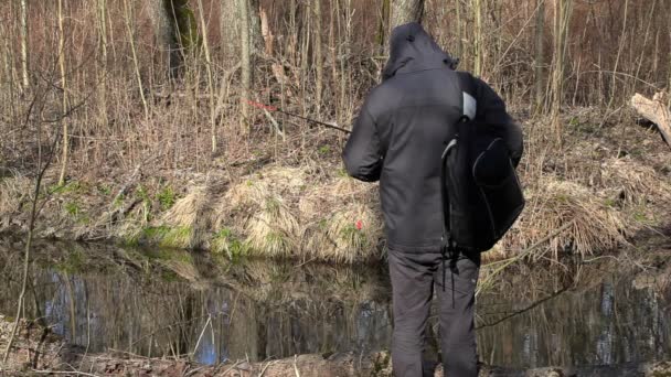 Man met rugzak beginnen te vissen in de buurt van rivier — Stockvideo