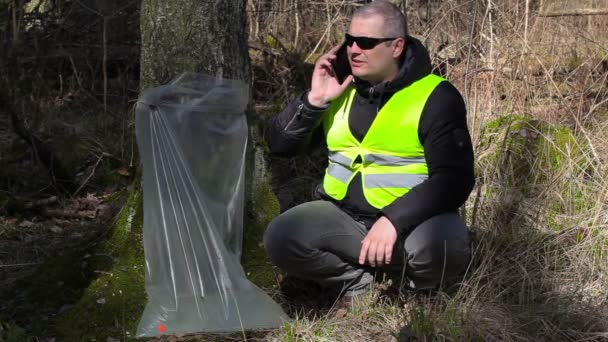 Forest Officer talking on smartphone near tree with birch juice — Stock Video