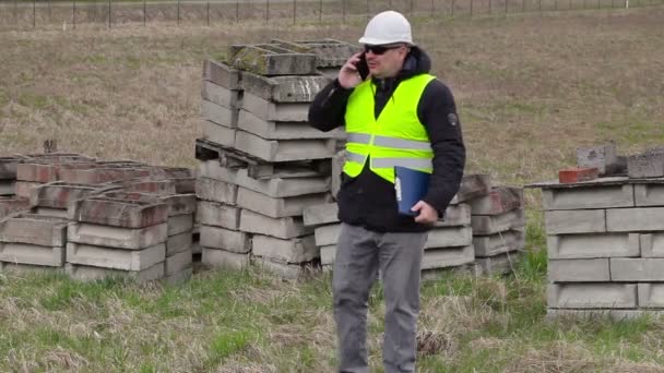 Civilingenjör med smarta telefonen på plats där kommer nya konstruktion webbplats — Stockvideo