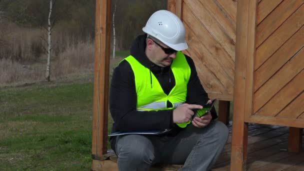 Civilingenjör med hjälp av tablet Pc på trä strukturen av byggnaden — Stockvideo