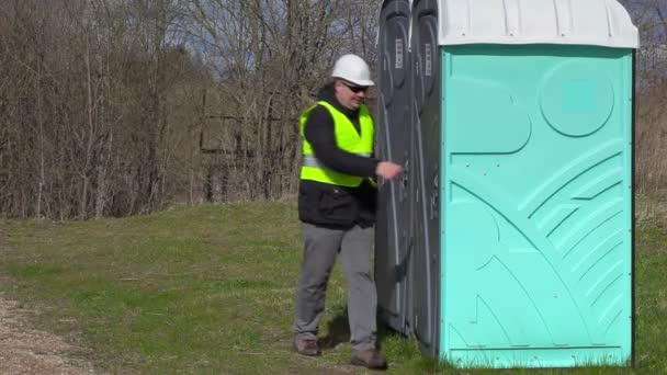 Worker waiting near portable toilet — Stock Video