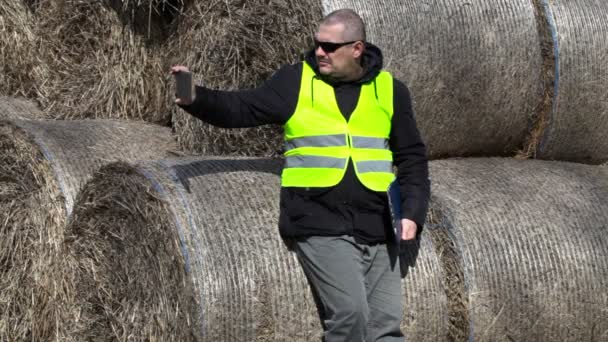 Farmer prendre des photos sur tablette PC près des balles de foin — Video