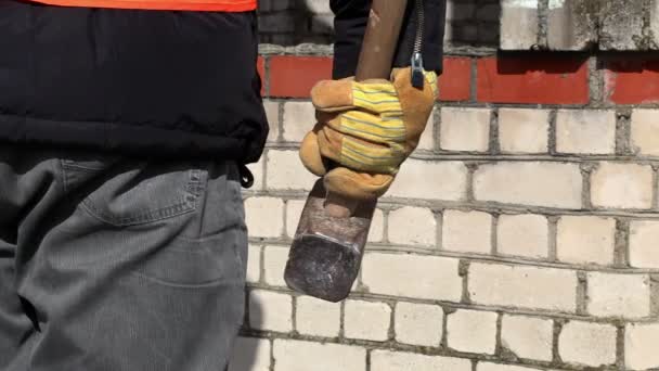 Trabajador con martillo cerca de la pared de ladrillo — Vídeos de Stock