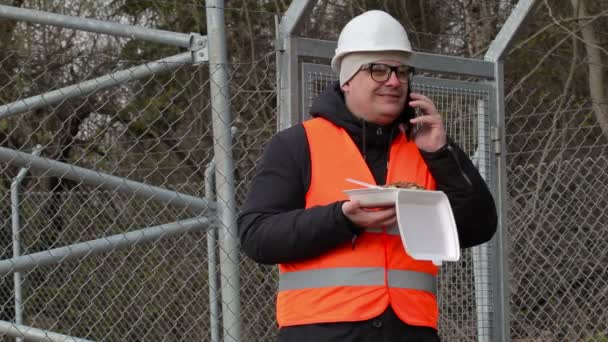Pracownik z jedzeniem rozmawia inteligentny telefon — Wideo stockowe