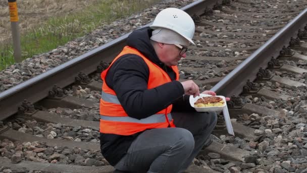 Trabajador sentado y comiendo en el ferrocarril — Vídeo de stock