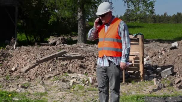 Bauarbeiter geht und telefoniert mit Smartphone — Stockvideo