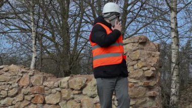 Eski bina kalıntıları, cep telefonuyla konuşurken Müfettiş bina