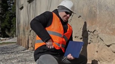 Eski duvarının yakınında cep telefonuyla konuşurken bina müfettişi