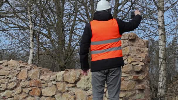 Bauinspektor macht Fotos auf Tablet-PC an der Ruine des Altbaus — Stockvideo