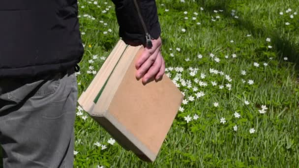 Homem com livros no prado verde — Vídeo de Stock