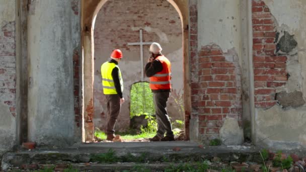 Bauinspektor telefoniert vor Restaurierung an alter Kirche — Stockvideo