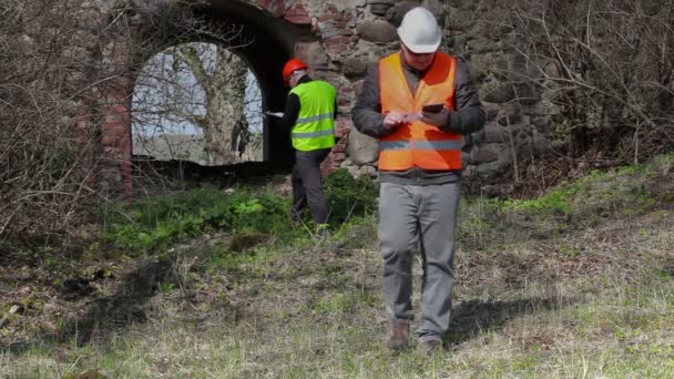 Bygga inspektör filma på tablet Pc på gamla ruiner före restaurering — Stockvideo