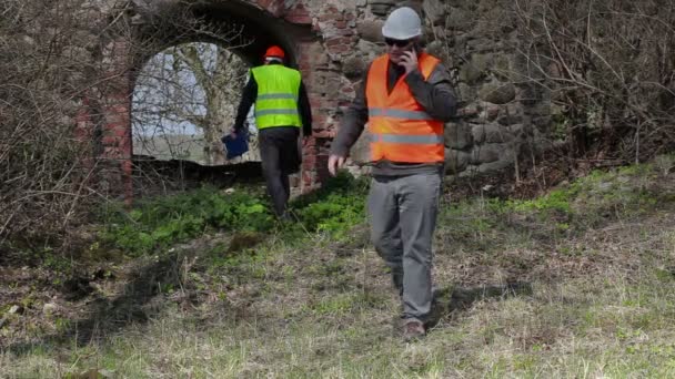 Budynku Inspektor rozmawia inteligentny telefon stare ruiny przed odbudową — Wideo stockowe