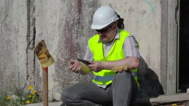 Kızgın inşaat işçisi ile tablet Pc duvarının yakınında 