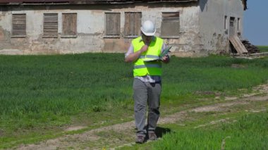 Çim alan eski terk edilmiş, hasarlı evin yakınındaki yazma bina müfettişi 