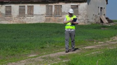 Tablet Pc çim alan eski terk edilmiş, hasarlı evin yakınındaki filme bina müfettişi 