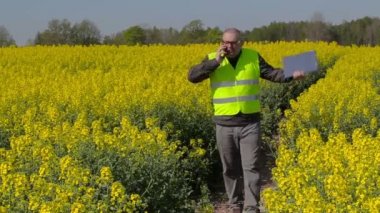 Akıllı telefonda konuşurken ve tecavüz sahada yürüme çiftçi 
