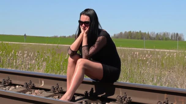 Депрессивная женщина сидит на железной дороге — стоковое видео