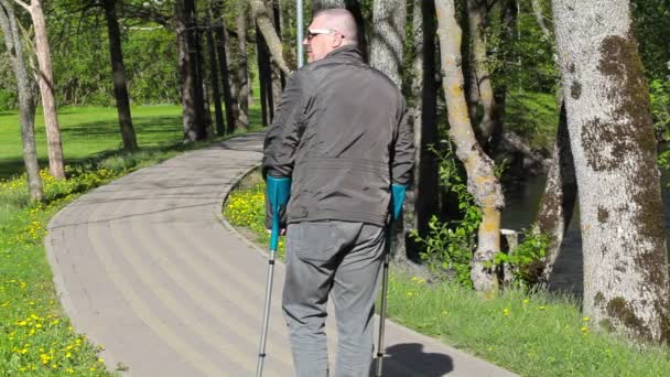 Gehandicapte man met krukken weglopen op pad — Stockvideo