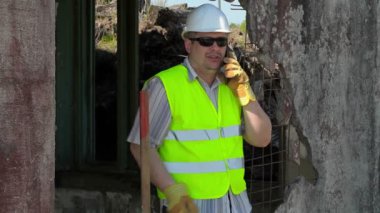 Akıllı telefonda konuşurken inşaat işçisi 