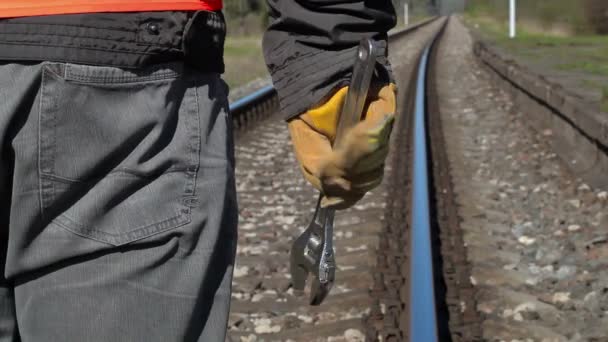 Железнодорожник с регулируемым гаечным ключом на железной дороге весной — стоковое видео