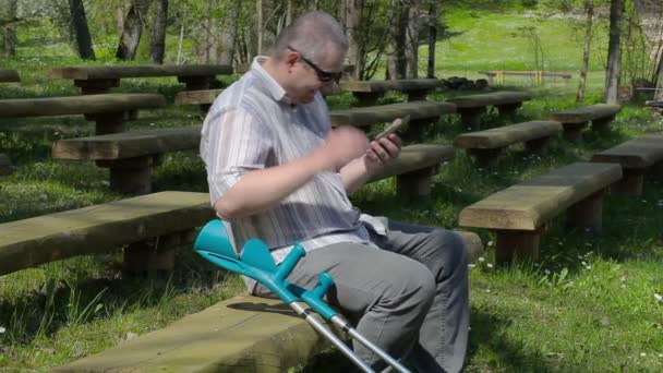 Gelukkig gehandicapte man met krukken lachen in het park — Stockvideo