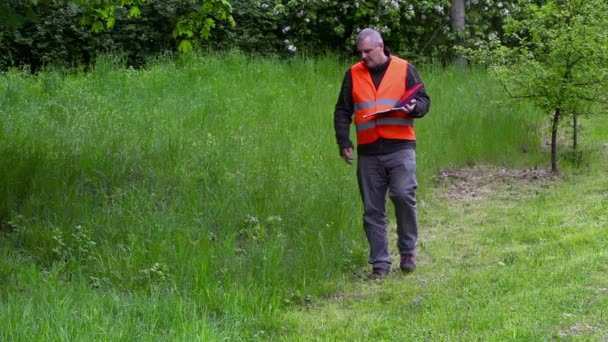 Landschappelijk manager schrijven in de buurt van het slechte kwaliteit snijden gras — Stockvideo