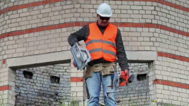 Construtor com ferramentas perto do edifício — Vídeo de Stock