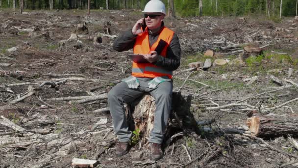 Milieu inspecteur praten over slimme telefoon in de verwoeste bos — Stockvideo