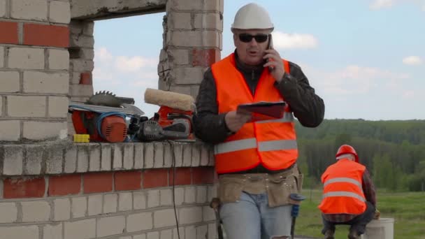 Будівельник п'є воду в літній день — стокове відео