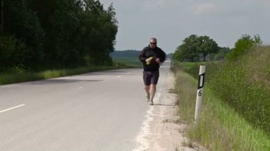 Karayolu kenarında koşan adam