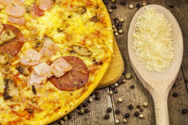 Peynir, pastırma ve salam ahşap masa üzerinde pizza