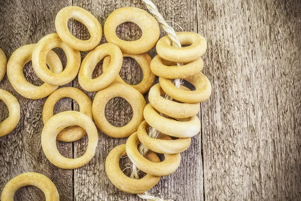 Bagels with rope on wooden table — Stock Photo, Image